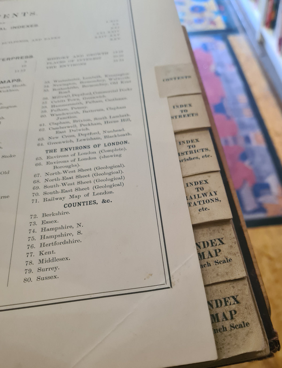 Close-up of an open book with visible text and a colorful map in the background.